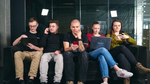 6 mensen die een video bekijken op laptops, smartphones & tablets